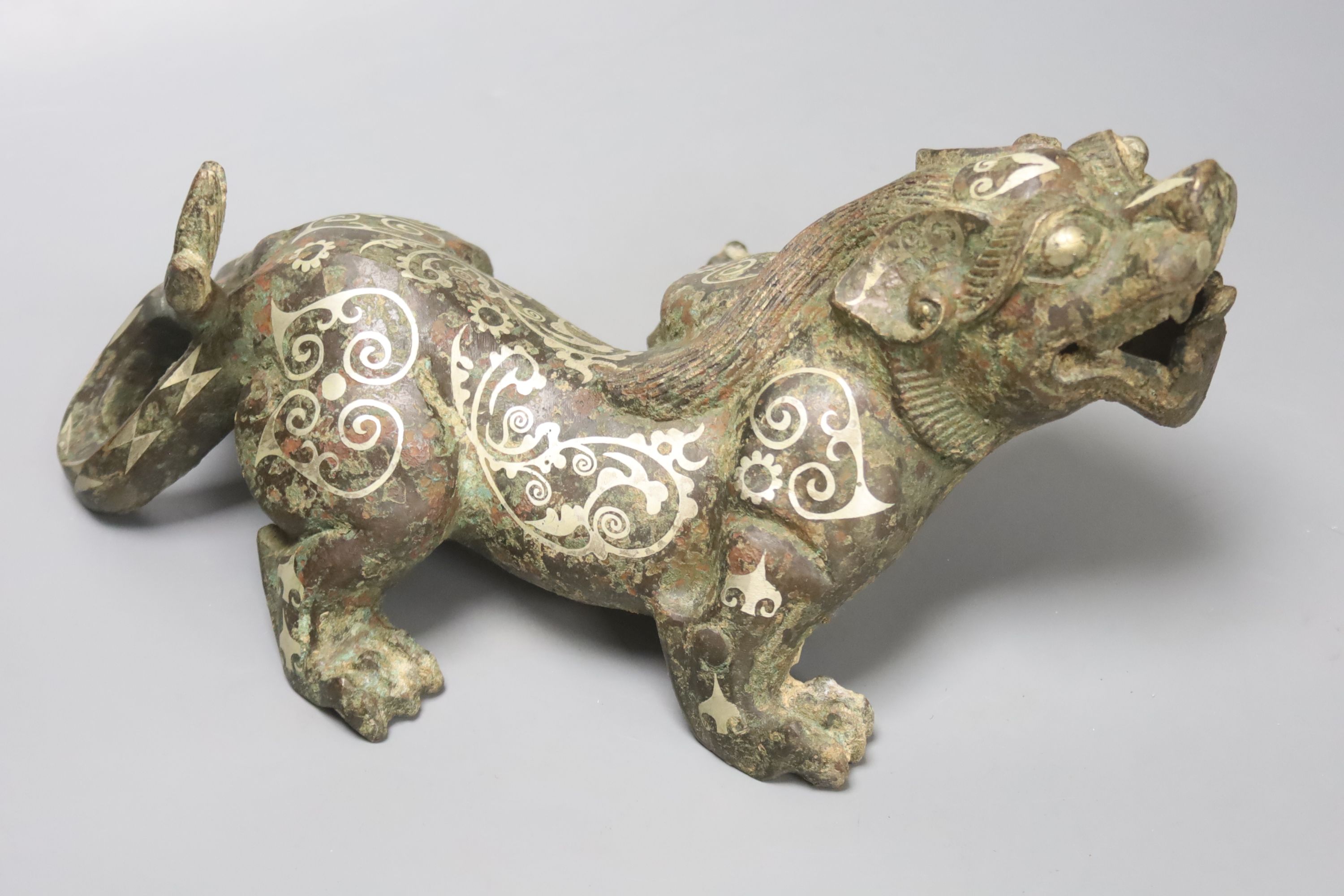 A Chinese inlaid bronze figure of a lion dog, Han dynasty style